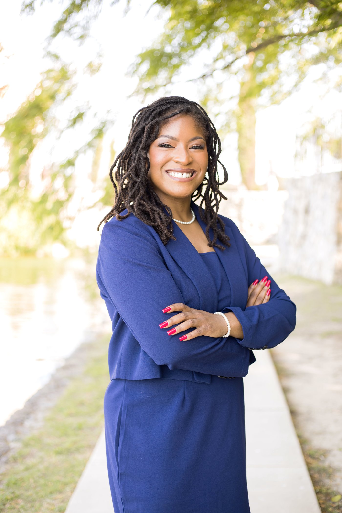 Dr. Christiana Redeaux, arms crossed, smiling outdoors